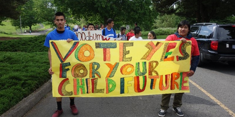 Young activists hold a sign during a protest.