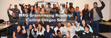 MRG Grantmaking Roadtrip! Central Oregon Stop. Picture of about two dozen age, race and gender diverse activists with arms raised in solidarity